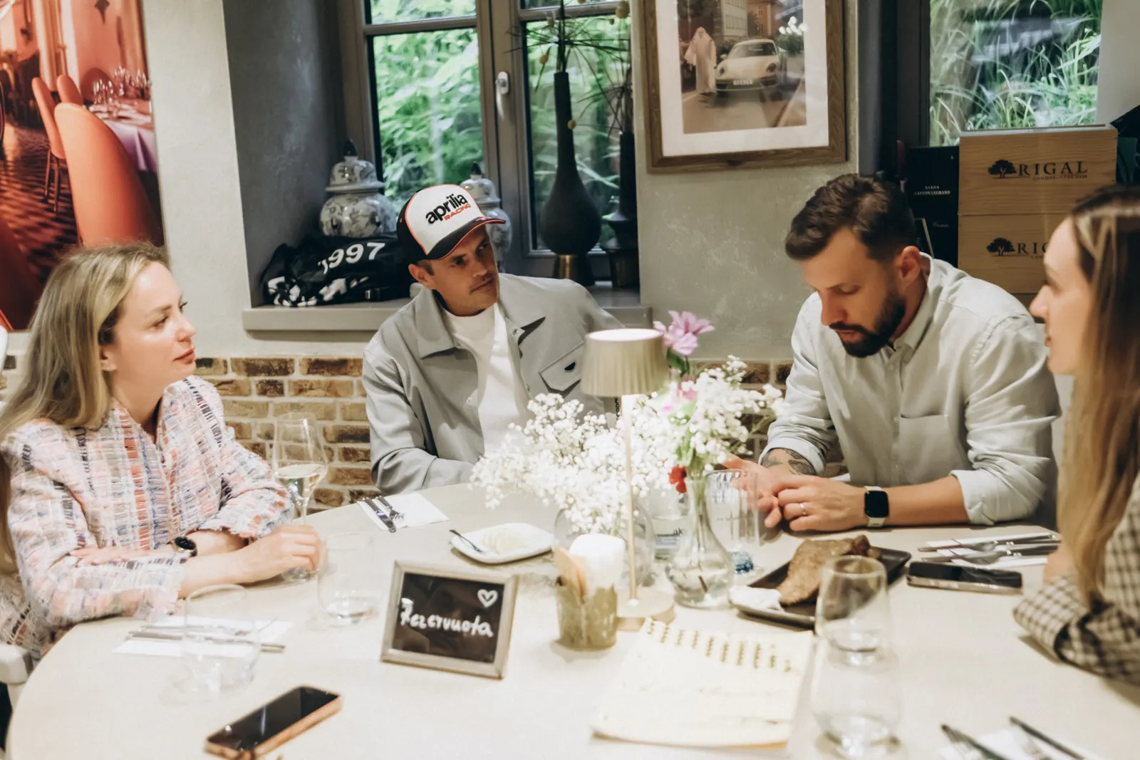 Joiner guests seated around a restaurant table with plates and glasses, talking over dinner