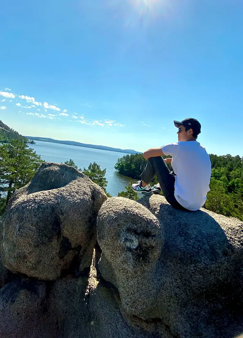 Eduard alone on a rock above a lake in Kazakhstan